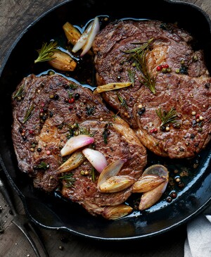 Roasted ribeye steaks in a cast iron pan