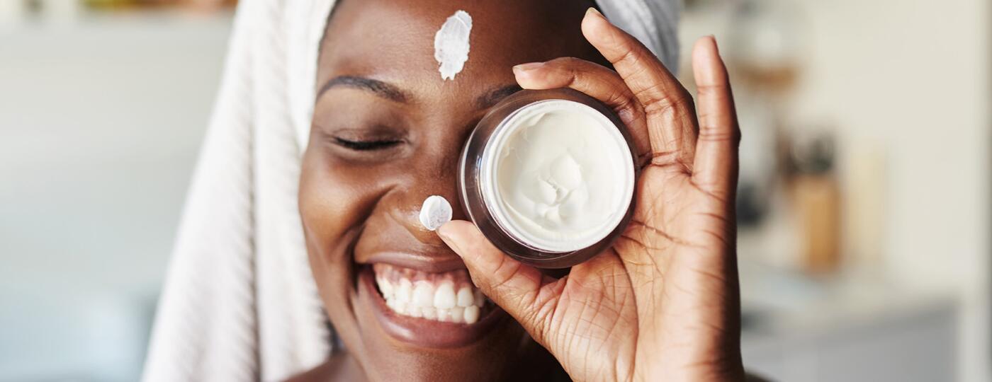 image_of_woman_holding_moisturizer_over_face_GettyImages-1280517978_1800
