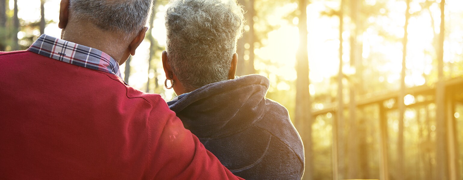 Active senior adult couple enjoy outdoor park at sunset.