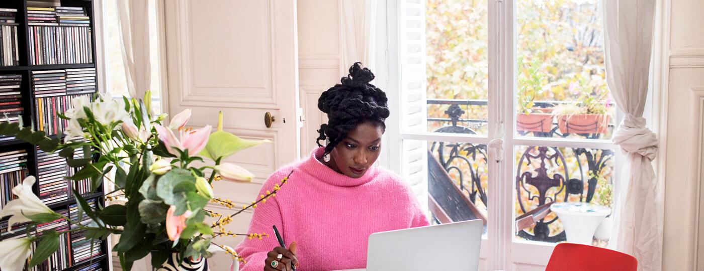 image_of_black_woman_sitting_at_table_working_on_laptop_GettyImages-1063295912_1540.jpg