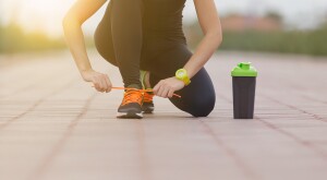 woman tying her shoe while exercising
