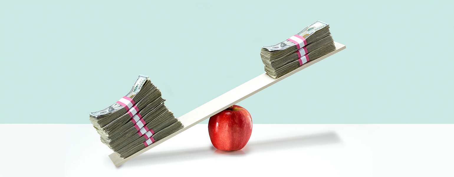 image of money on balance scale on top of apple