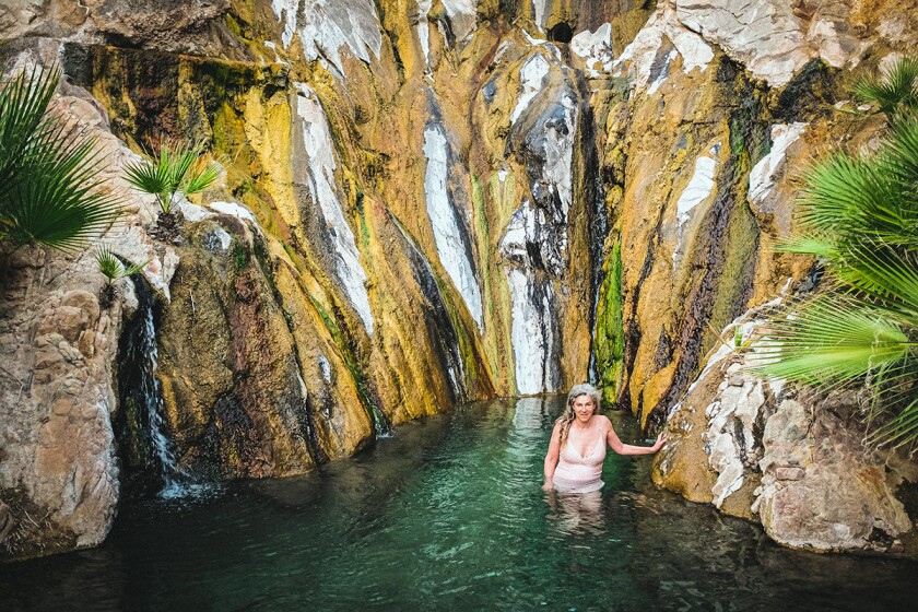 Woman in the water surrounded by rock formations at Castle Hot Springs