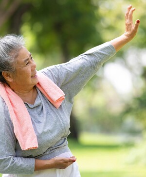 Mature woman doing tai chi outside on a nice day