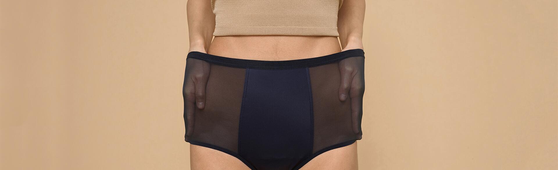 A woman stretches out the sides of her Thinx hi-waist panties, which can double for bladder leakage.