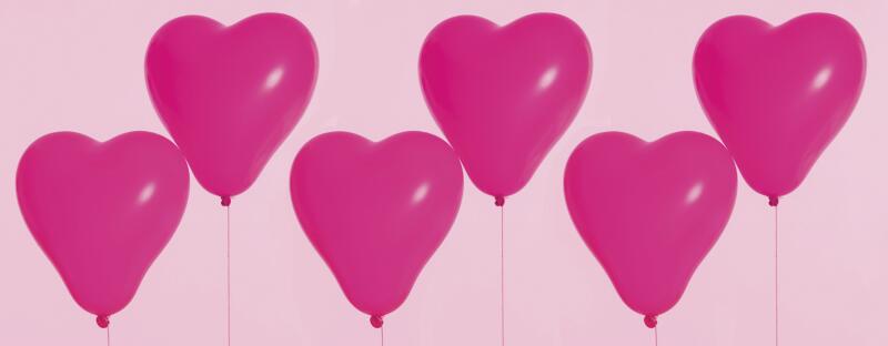 six pink heart balloons floating