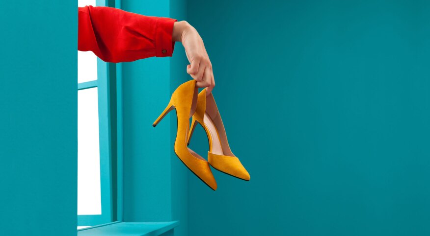 Woman throwing yellow high heels out a window
