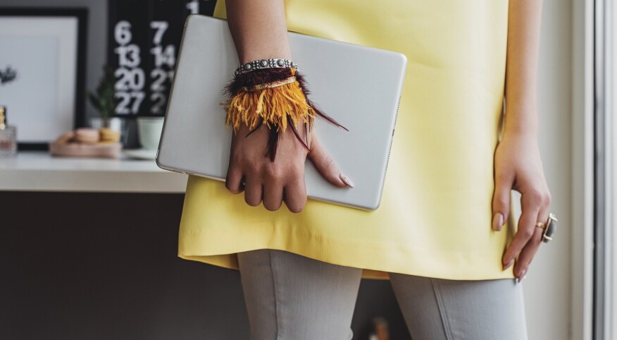 woman holding a tablet so she can take online courses at home