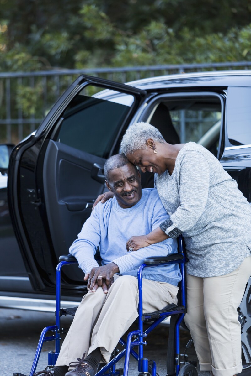 Disabled senior man in wheelchair with his devoted wife