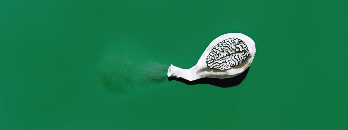 Deflated white balloon blowing out dust with a print of a brain on the balloon.
