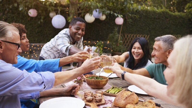 A group of friends enjoying an outdoor meal in a backyard