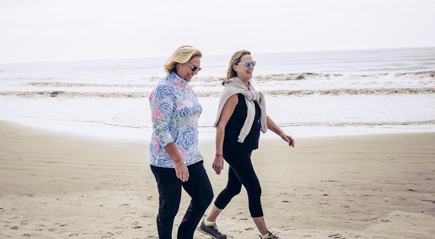 Two women walk on a beach