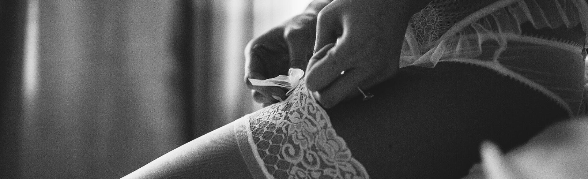 Boudoir photo shoot with woman in lingerie and showing garter on her thigh
