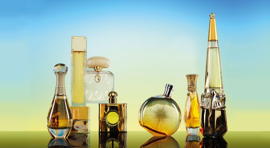 Seven Perfume bottles on a gradient blue to yellow background