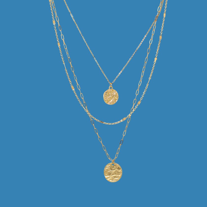 Three gold layered necklaces on white background