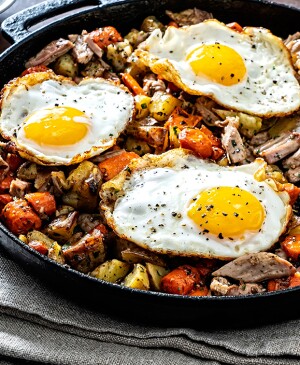 Turkey breakfast skillet with fried eggs in cast iron pan