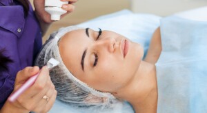 woman getting chemical peel done by cosmetologist
