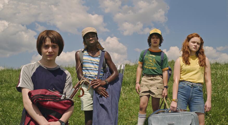 Awesome TV shows Stranger Things cast in a field from season 3