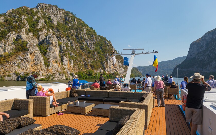 Guests on the AmaCerto’s Sun Deck sail through the Iron Gates on the Lower Danube River.