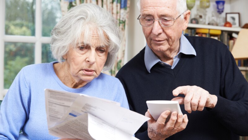 Senior Couple At Home With Bills Worried About Home Finances
