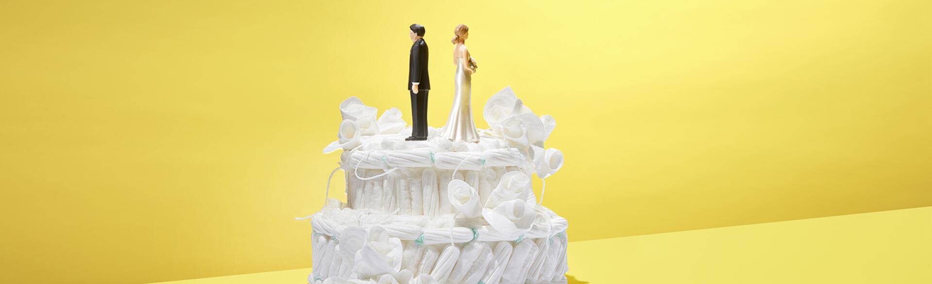 Wedding cake made out of tampons with bride and groom figurines on top.