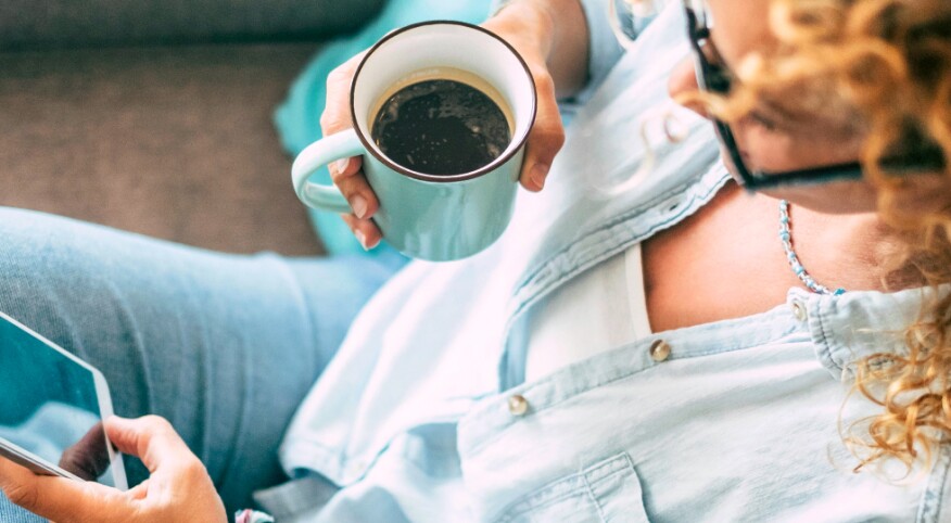 Woman on her cozy couch looking at her phone