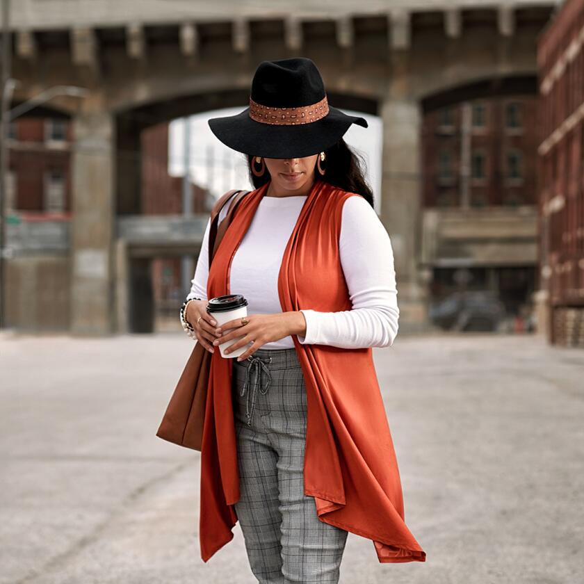 Woman wearing orange vest with hat