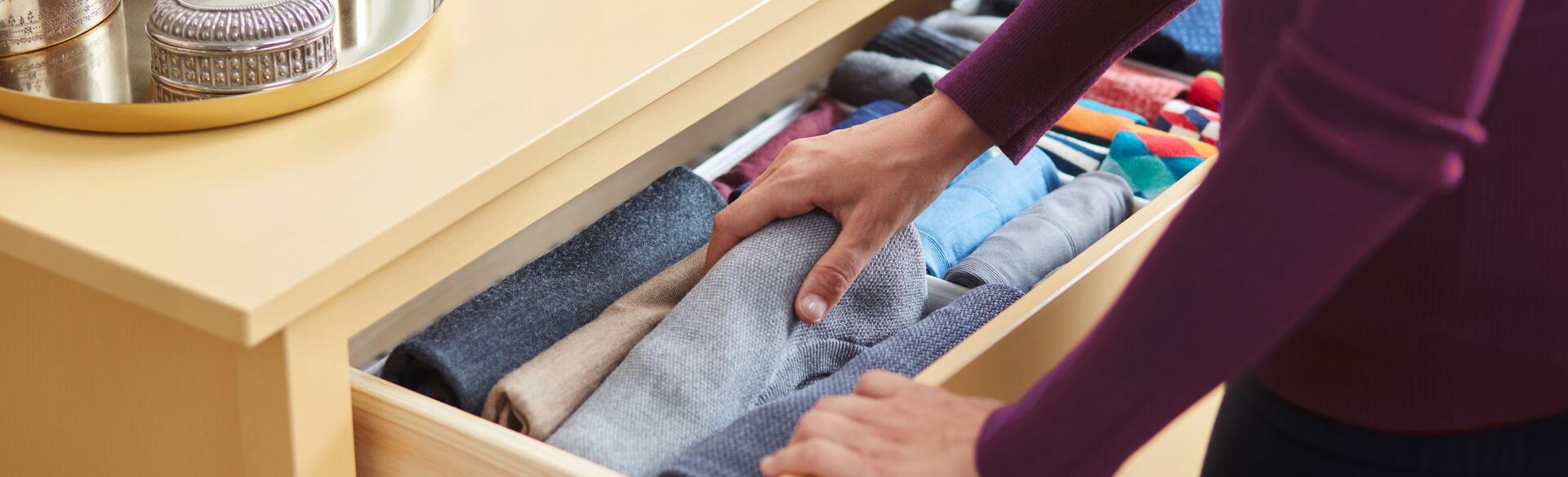 Woman organizing clothes in a dresser drawer