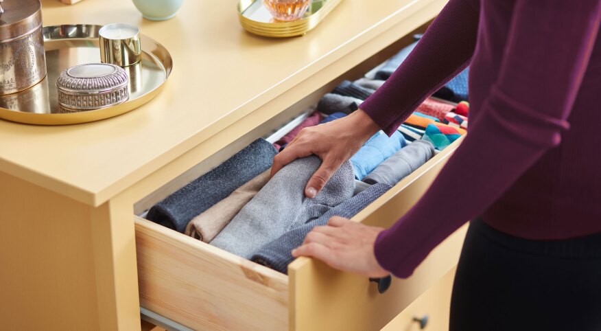 Woman organizing clothes in a dresser drawer