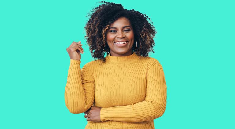 Portrait of smiling beautiful Afro woman standing against white background