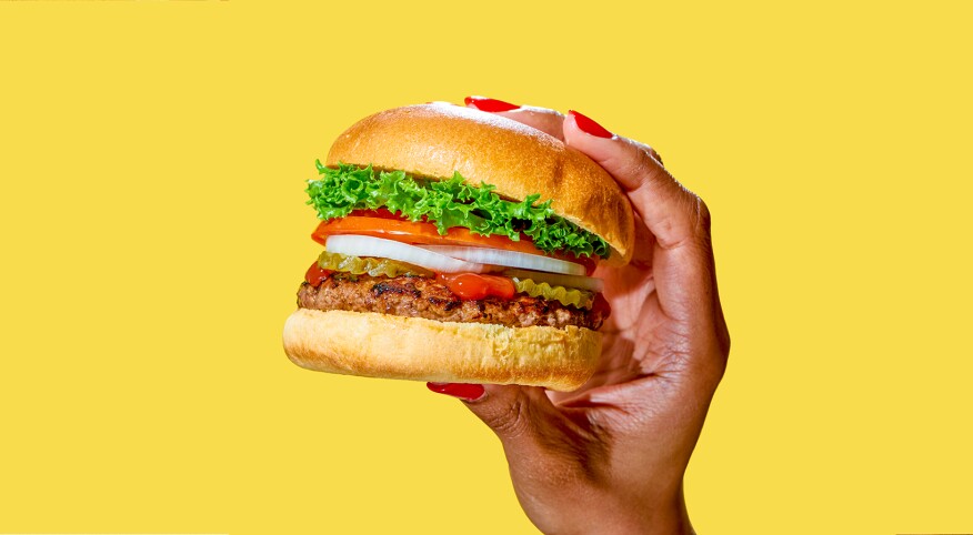African American woman's hand holding a delicious looking burger