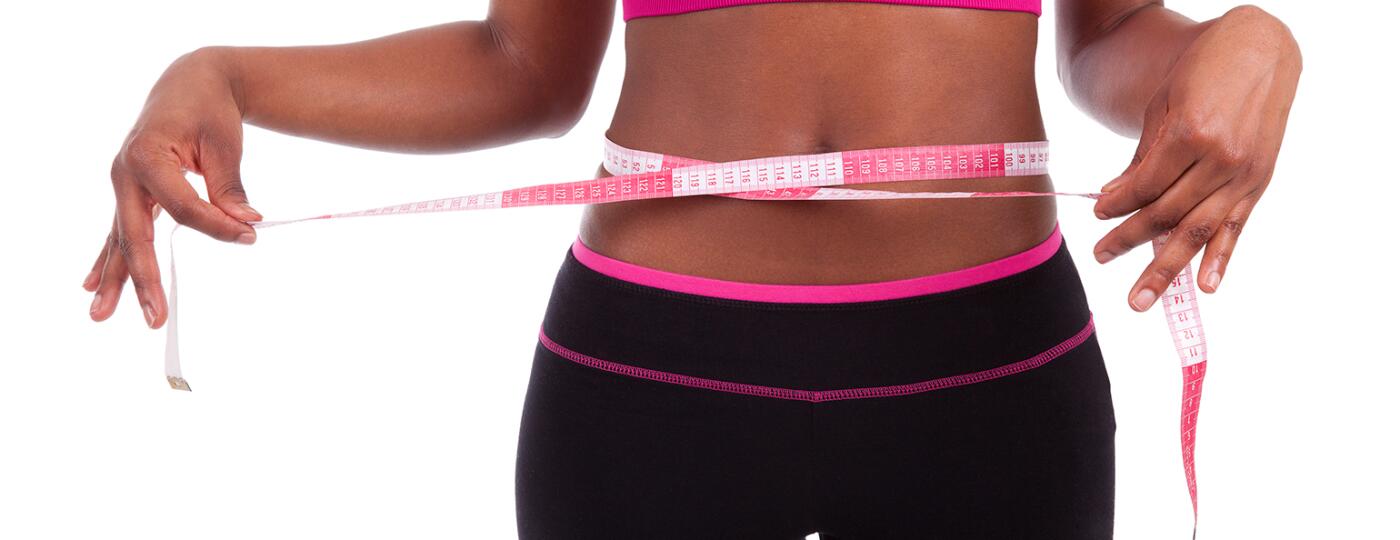 African American athlete with tape measure around stomach