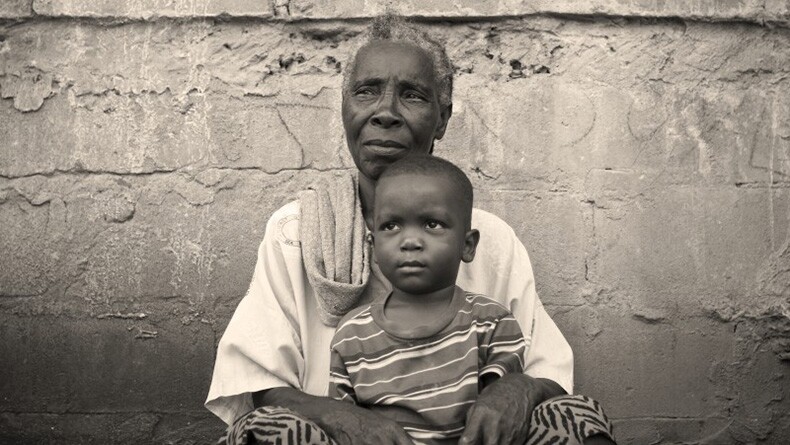 An African grandmother sits with a grandchild.