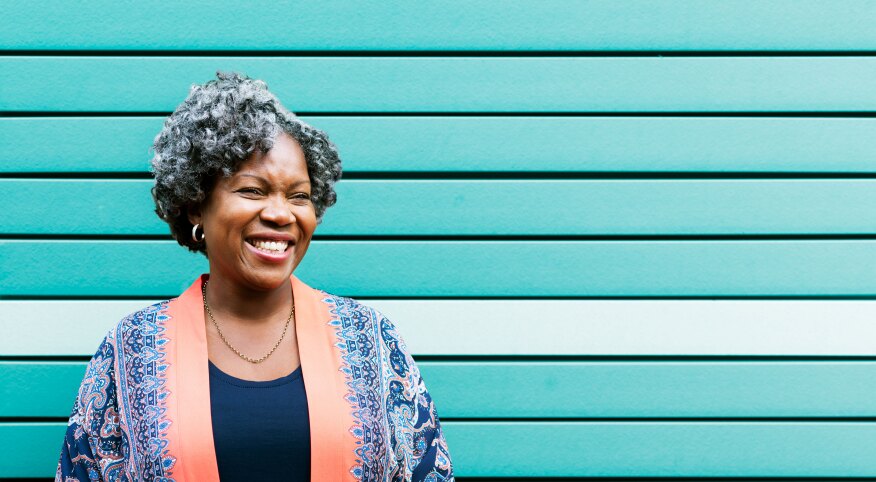 Woman smiling in front of a turquoise wall