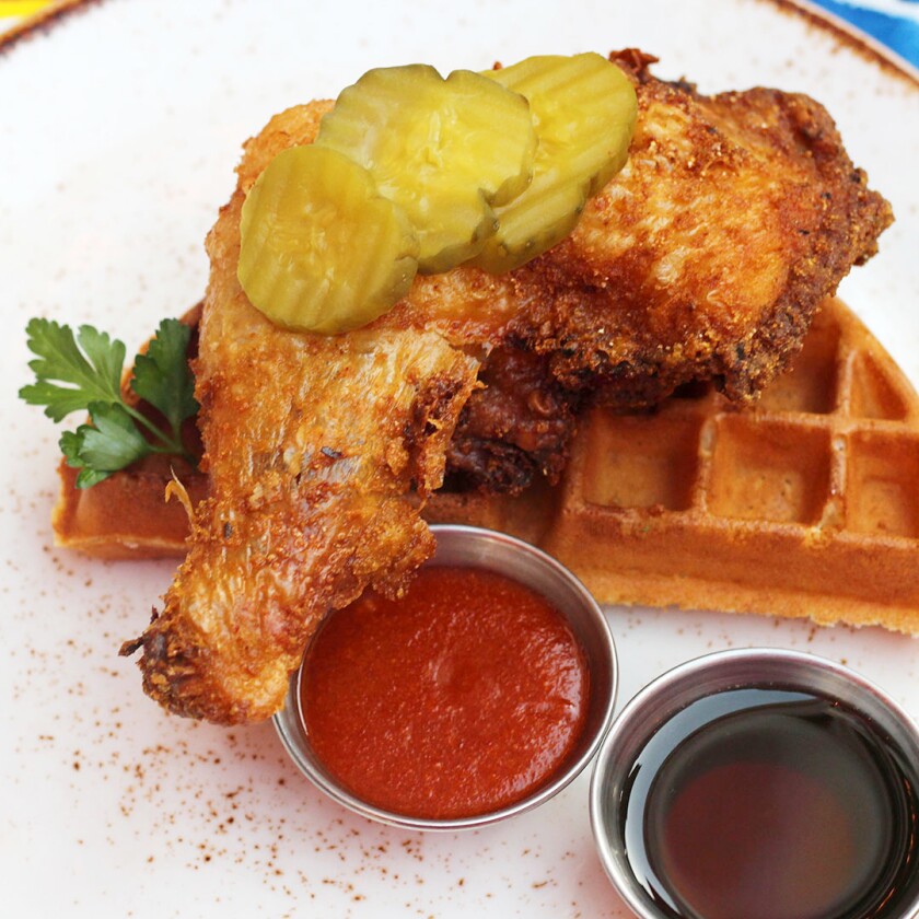 Chicken and waffles plated with pickles