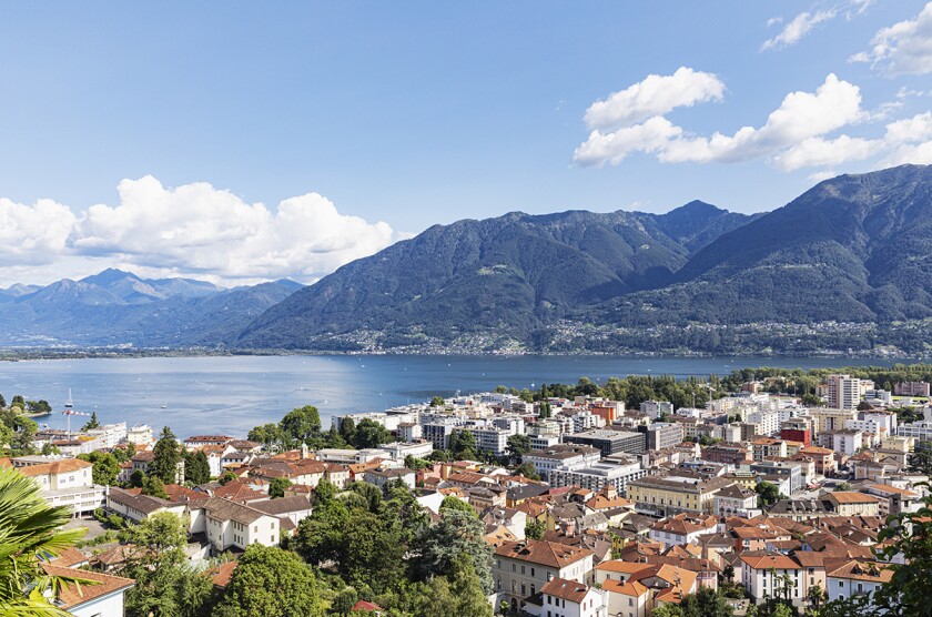 Switzerland, Ticino, Locarno, City houses with Lake Maggiore and surrounding mountains in background
