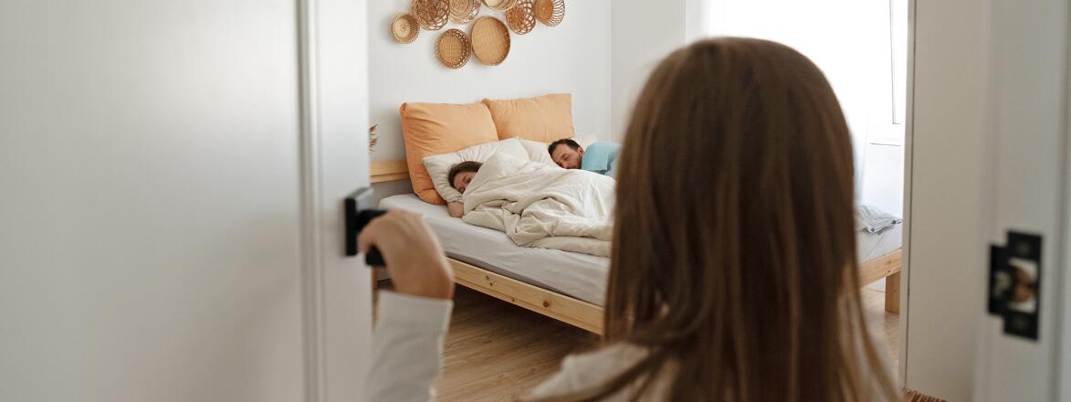 Child looking into parents bedroom while they're sleeping