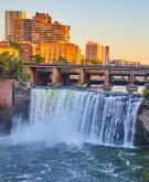 Rochester New York stunning natural waterfall next to downtown skyline at sunset