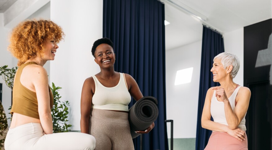 Three friends chatting in a Pilates Studio