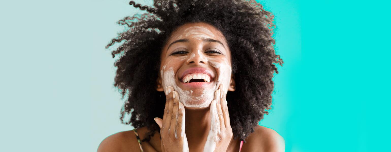 A woman washing her face to combat signs of aging.
