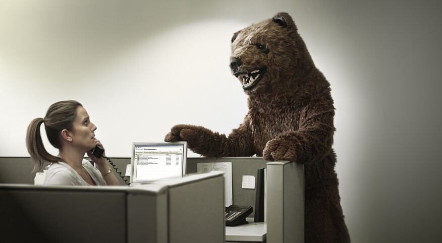 woman at work in cubicle with boss in bear costume standing over her desk