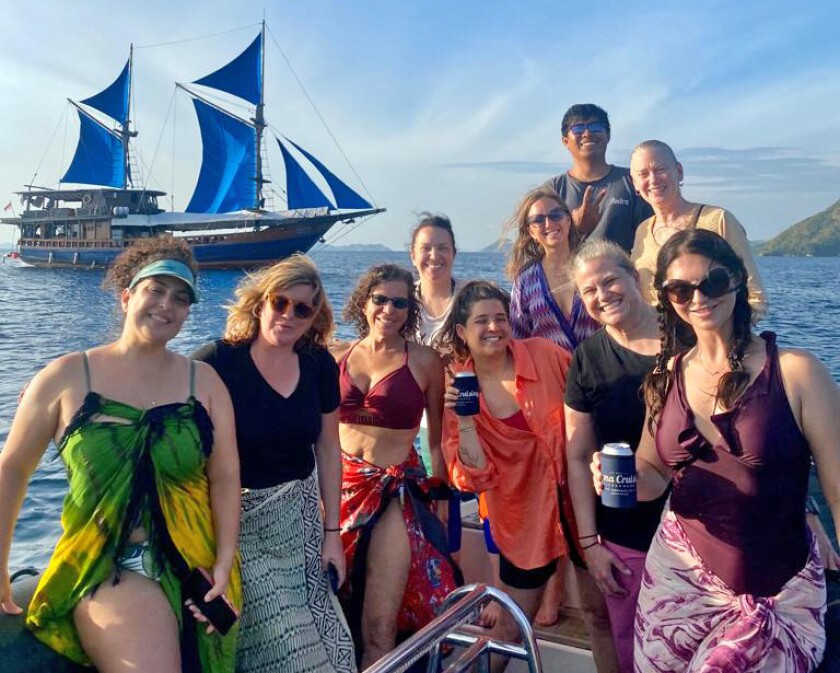 Women on a beautiful diving vacation in Indonesia with their boat in the background