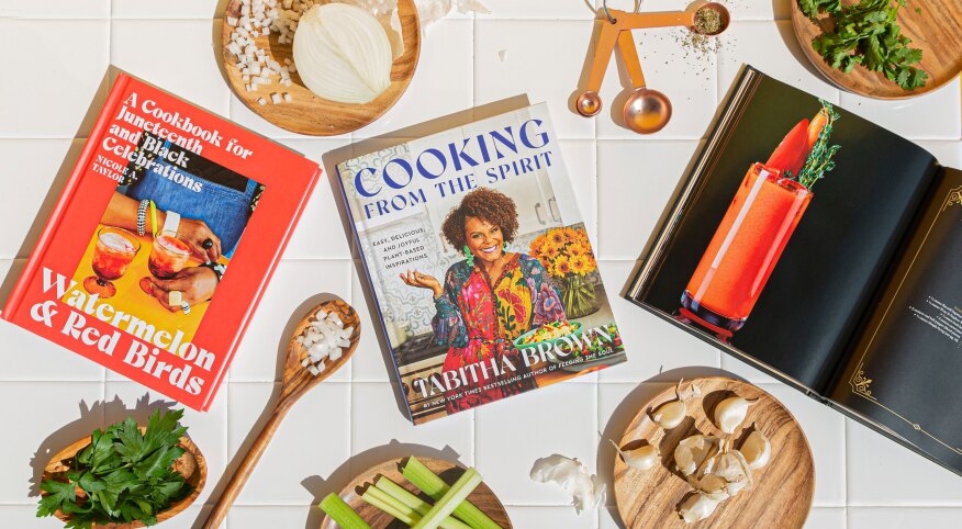 Still-life of cook books and ingredients on white tile surface