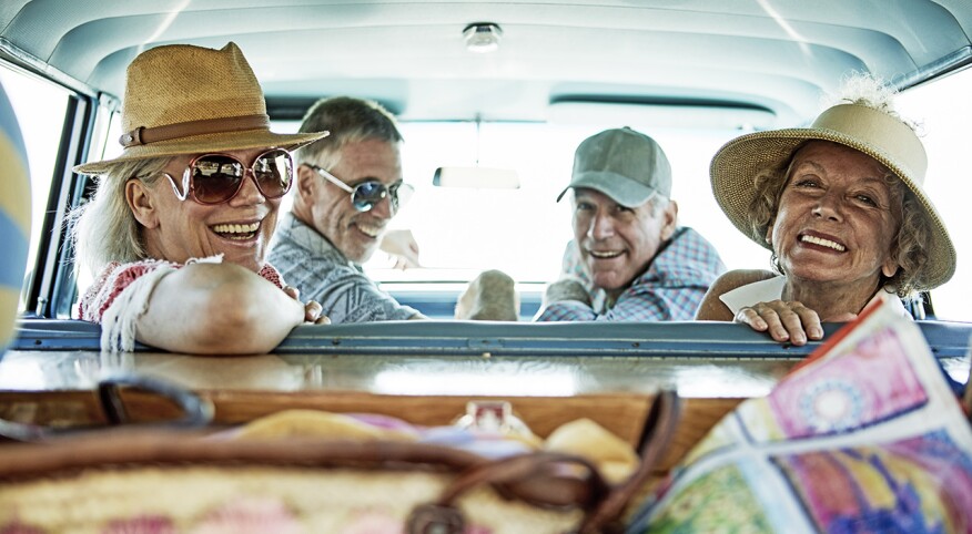 Four senior friends on a road trip; inside car