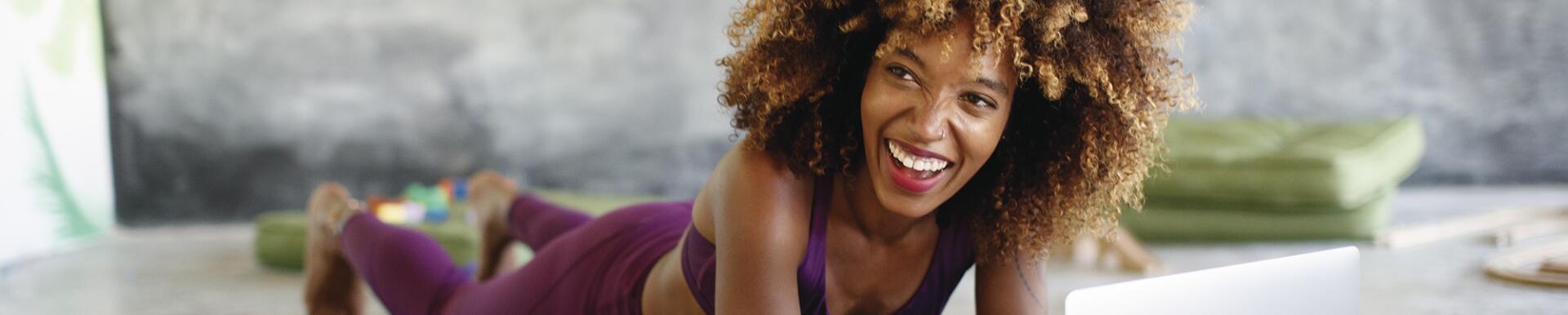 Woman on her laptop at home taking online fitness classes