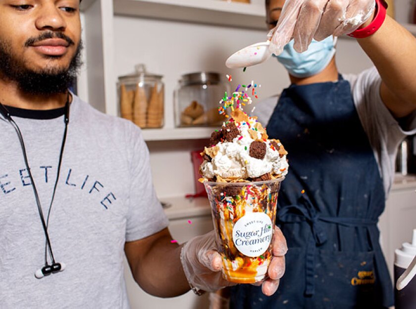Sprinkles being poured on a sundae at Sugar Hill Creamery in Harlem, NYC.