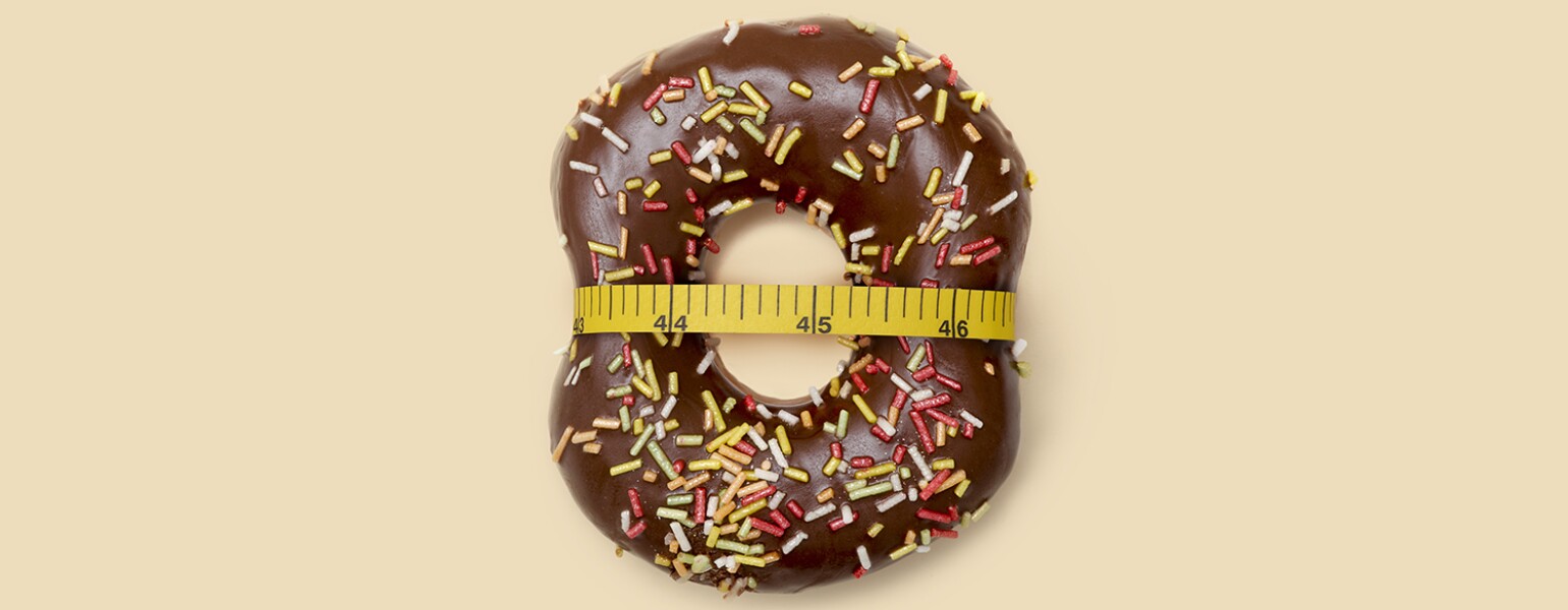 doughnut with measuring tape around it to represent losing weight after menopause