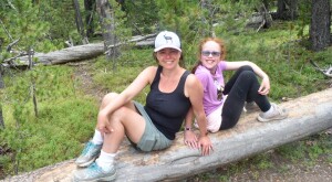 photo of author and her daughter outside hiking sitting on a log