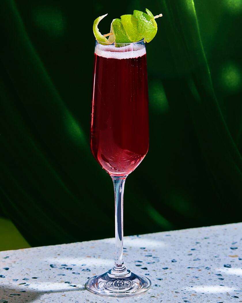Holiday cocktail on glossy table in front of green curtain