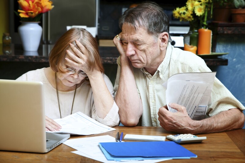 Senior couple at home with many bills